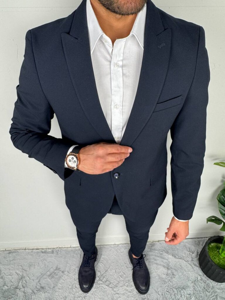 Elegantno muško odelo od vune u tamnoplavoj boji, sa slim-fit krojem i dugmićima na manžetnama, idealno za poslovne prilike i svečane događaje.