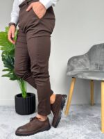 Muška cipela braon boje sa pertlama u bočnom prikazu, model sedi sa nogom prekrštenom