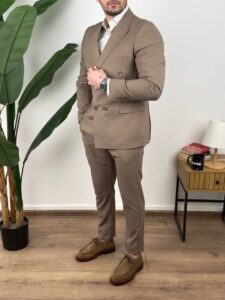 Detalj gornjeg dela muškog odela vizon sa dvorednim kopčanjem, ruke u džepovima pantalona