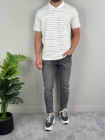 Model u beloj polo majici sa sivim prugama, svetle farmerke, kadar punog rasta