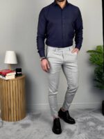 Elegantna muška košulja teget nijanse pored stilske lampe, frontalni stav sa rukom u džepu