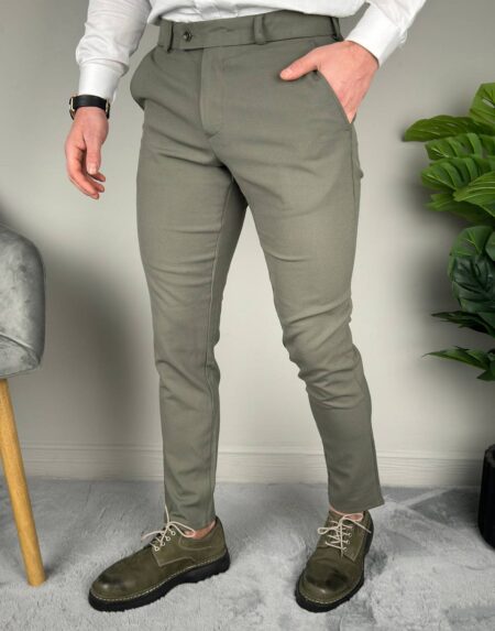 Maslinaste elegantne muške pantalone, ruka u bočnom džepu i sat na zglobu, frontalan kadar