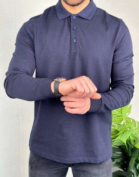 Teget muška polo majica dugi rukavi, model stoji frontalno, ruke opuštene