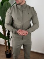Maslinasta trenerka komplet snimljena pod blagim uglom, vidljiv kroj nogavica