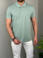 Mint pamučna muška polo majica na modelu, frontalni prikaz uz bele pantalone
