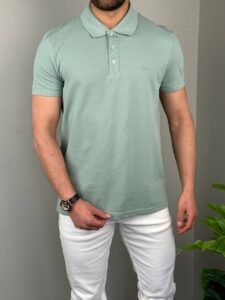 Mint pamučna muška polo majica na modelu, frontalni prikaz uz bele pantalone