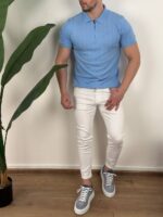 Svetloplava muška polo majica sa zipom uz bele pantalone u celom stavu