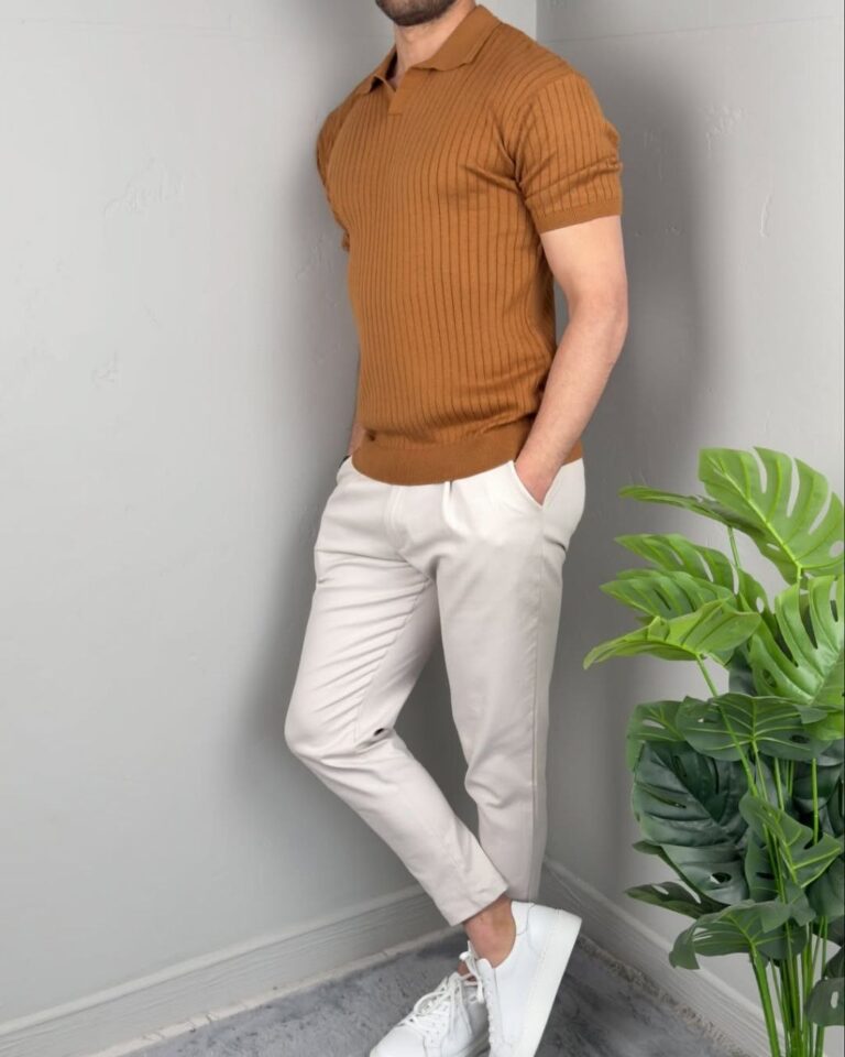 Oker polo majica M9270 sa belim pantalonama, model stoji ispred svetlog zida sa biljkom