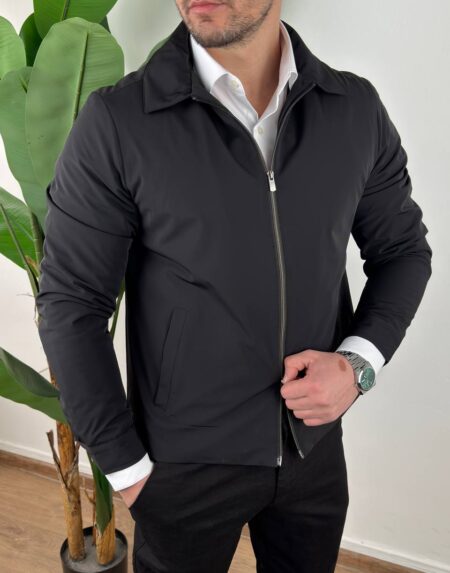 Crna muška prelazna jakna two-way zip otvorena na modelu uz crne pantalone