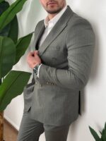 Maslinasto letnje odelo na pruge, pune dužine snimak, model stoji uspravno ispred zida