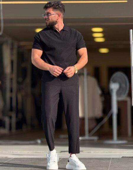 Crna polo majica i tamne pantalone, prednji kadar cele figure